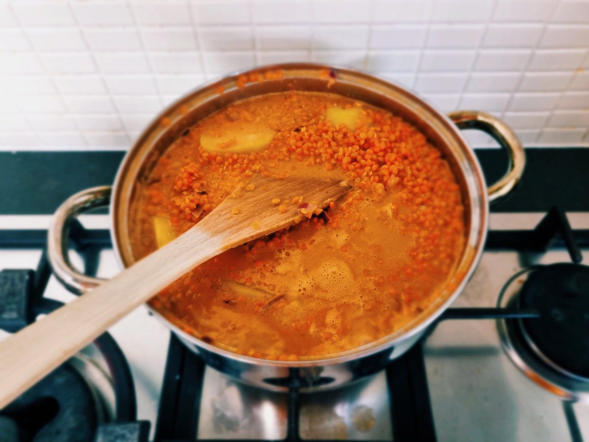 Vegan Massaman curry met biologische linzen en aardappels op het vuur.