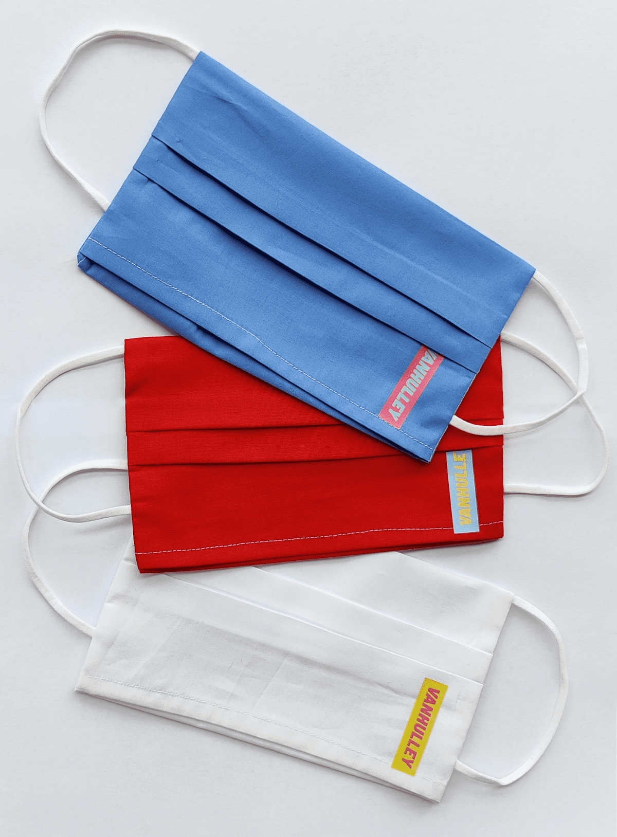 Drie mondkapjes in blauw, rood en wit, gemaakt door Gronings naaiatelier Vanhulley.